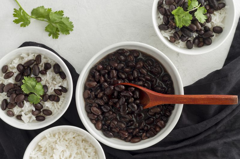 Feijão em pote ao lado de arroz