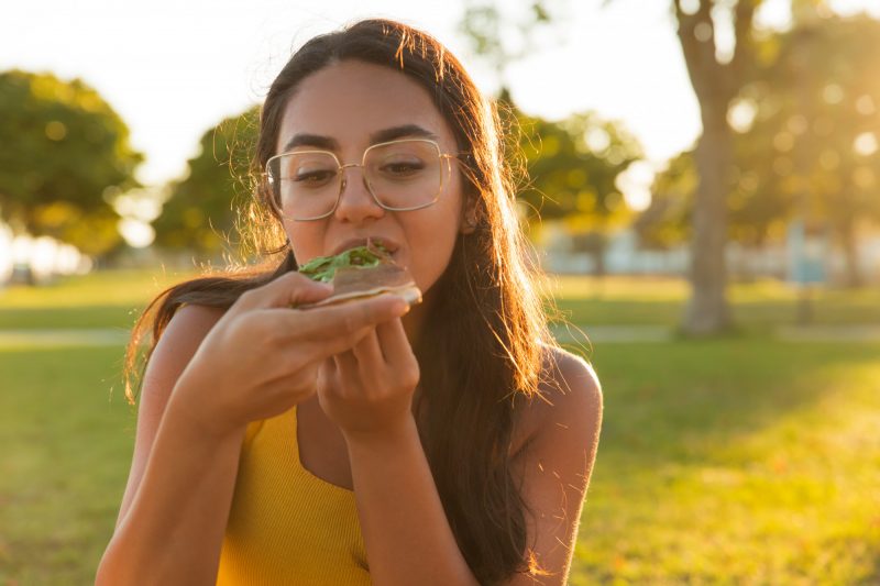 Mulher comendo um alimento rico em potássio 