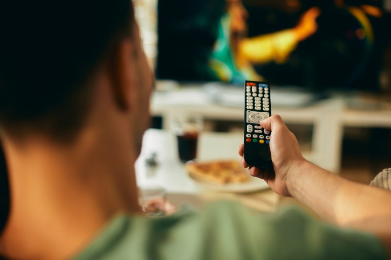 Homem assistindo televisão em sua sala 