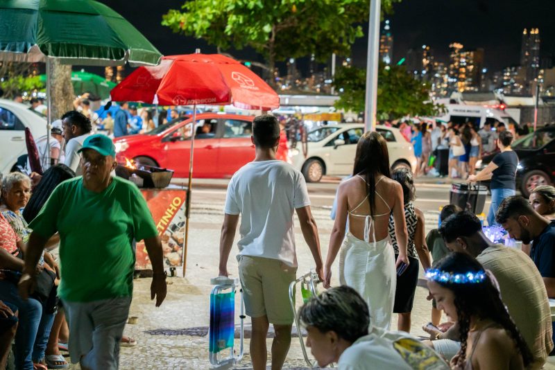 Foto mostra pessoas indo para a praia de Balneário Camboriú antes do réveillon