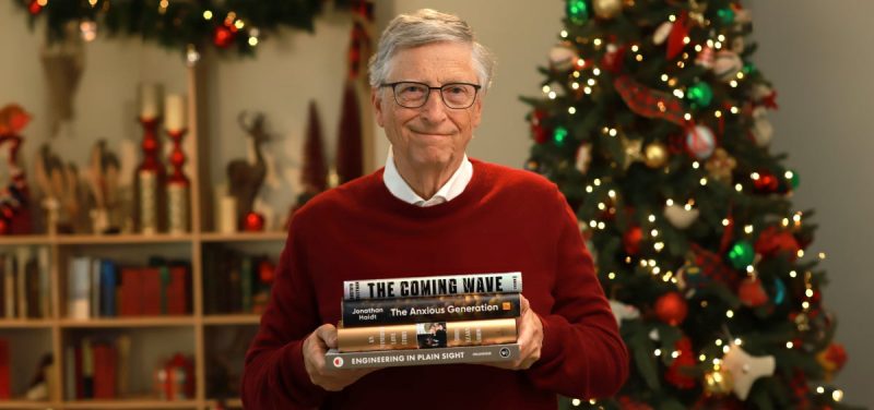 Bill Gates segurando livros que recomenda ler no fim de ano