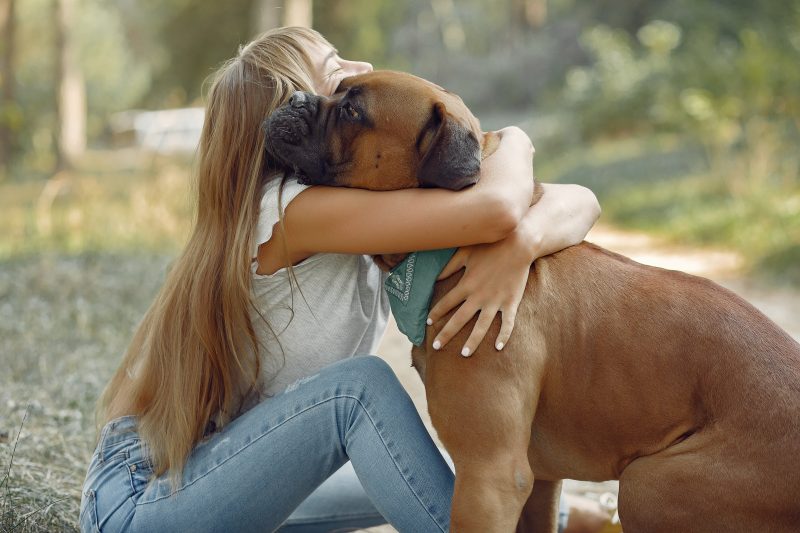 Menina loira abraçando seu cachorro