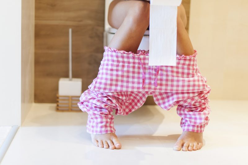 Mulher sentada no vaso sanitário 