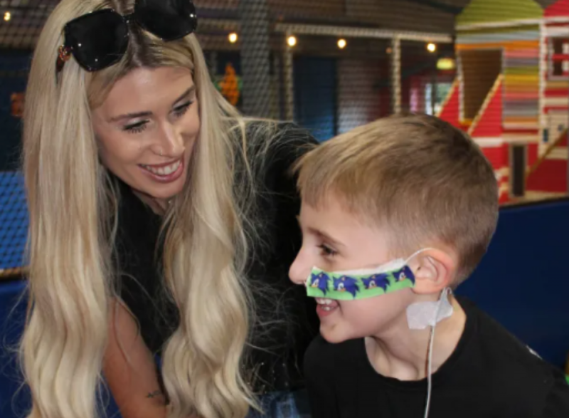 Menino pousando para foto com sua mãe 