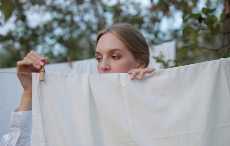 aparece uma mulher pendurando as roupas após desamassar as roupas