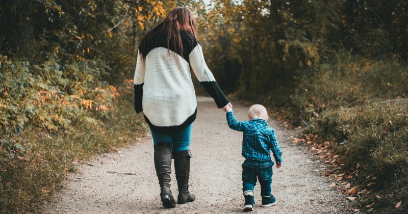 Mãe levando filho em estrada