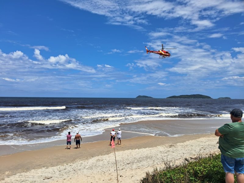 Praia do Ervino com socorristas realizando buscas pelo homem desaparecido