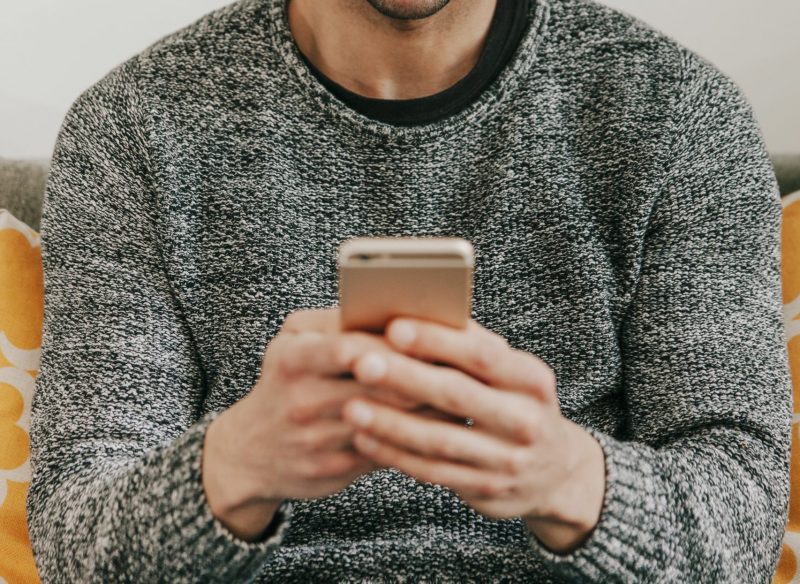 Imagem ilustrativa mostra homem segurando um celular. Réu foi condenado por enviar áudio mal-educado 