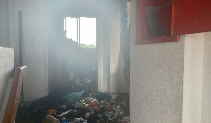 Incêndio em apartamento em Florianópolis, foto mostra apartamento destruído com destroços e fumaça