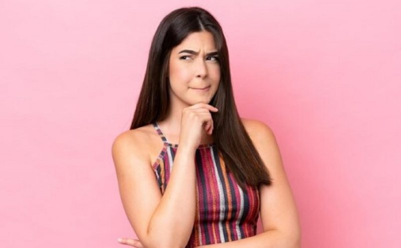 na foto aparece uma mulher atenta e indecisa ao desconfiar de uma pessoa