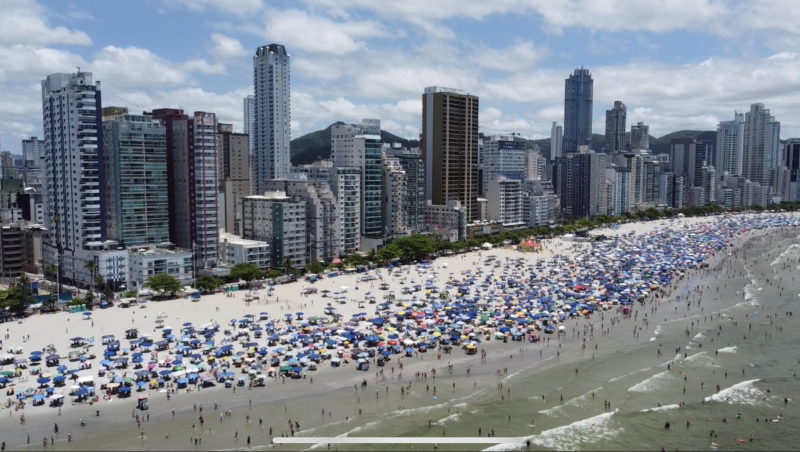 Foto de praia cheia ilustra matéria sobre ocupação hoteleira durante Ano-Novo em Balneário Camboriú