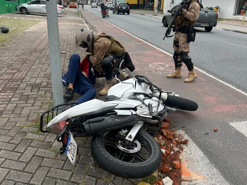 Foto mostra moto caída com condutor após acidente durante perseguição policial