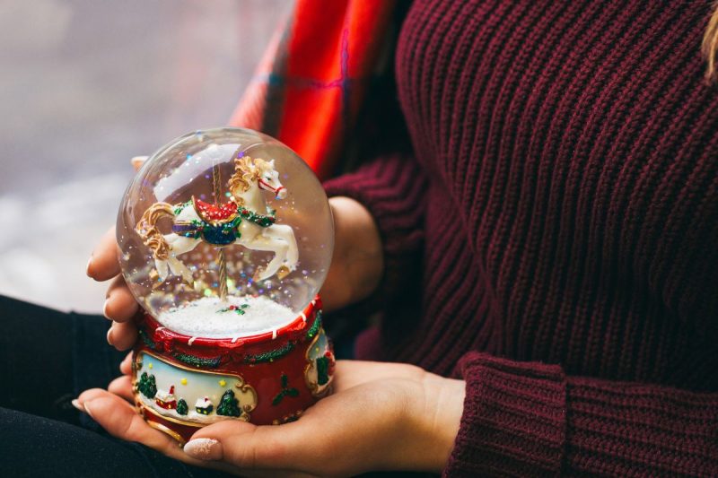 mulher segurando um globo de neve de natal 
