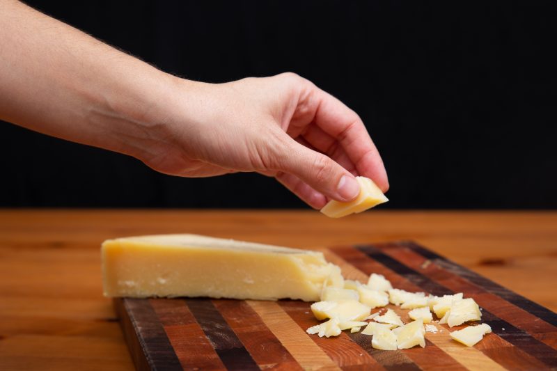 Mão pegando um pedaço de queijo 