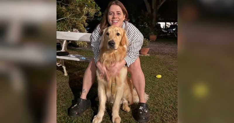 Tati Machado sentada em local abraçando um cachorro