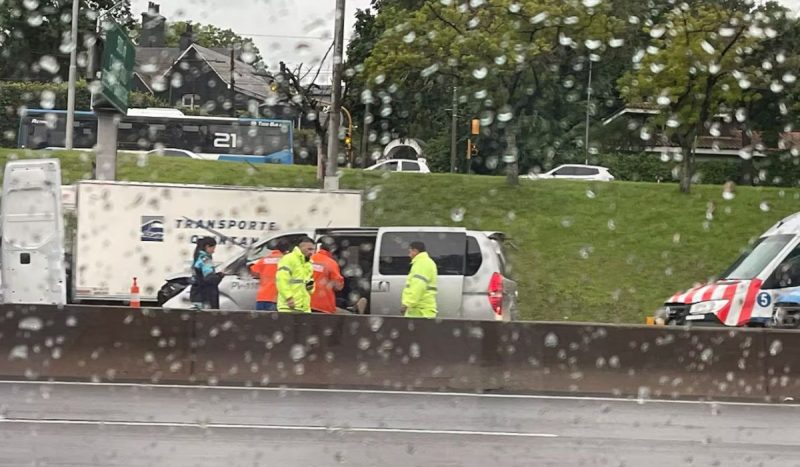 Policiais morrem atropelados atendendo acidente, foto mostra agentes perto de carro enquanto chove