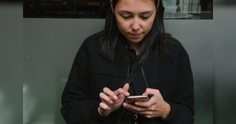 Mulher mexendo no celular séria