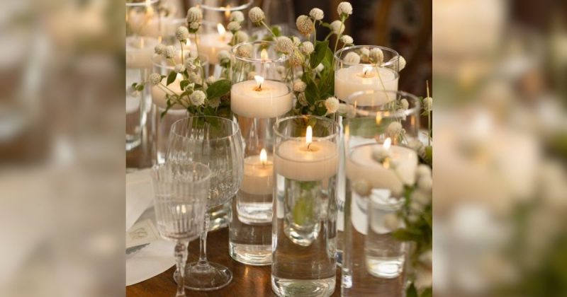 Velas na mesa com copos e flores