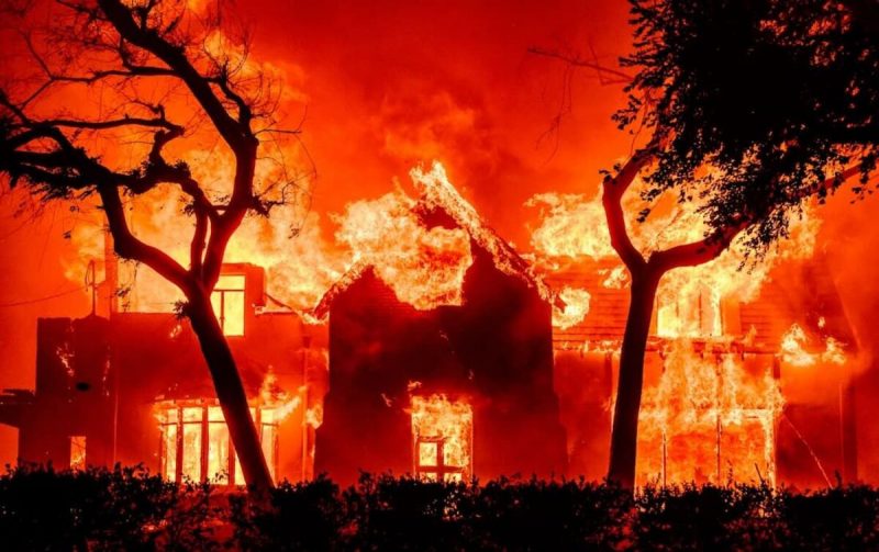 na foto aparece fogo consumindo uma casa sendo consumida pelos incêndios em Los Angeles