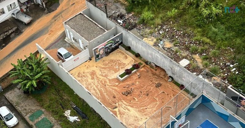 Imagem aérea mostra o acúmulo da chuva derruba muro de condomínio na praia Brava em Itajaí