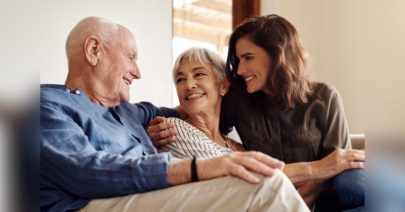 Pessoas sentadas em sofá sorridentes