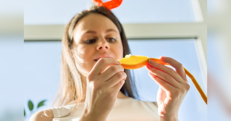 Mulher comendo laranja