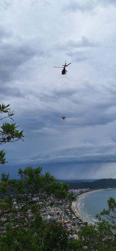 imagem mostra mulher sendo içada pelo helicóptero Arcanjo