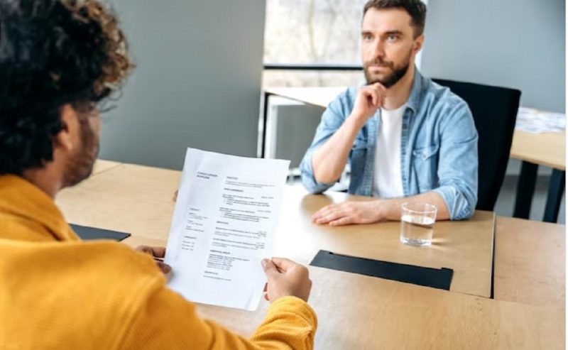 na foto aparece um homem que costuma tocar o rosto durante uma dúvida na entrevista de emprego