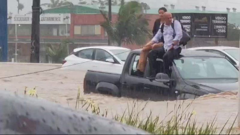 Em meio às chuvas em Santa Catarina, motoristas subiram no teto de veículos para se proteger da enxurrada - Foto: Reprodução/ND