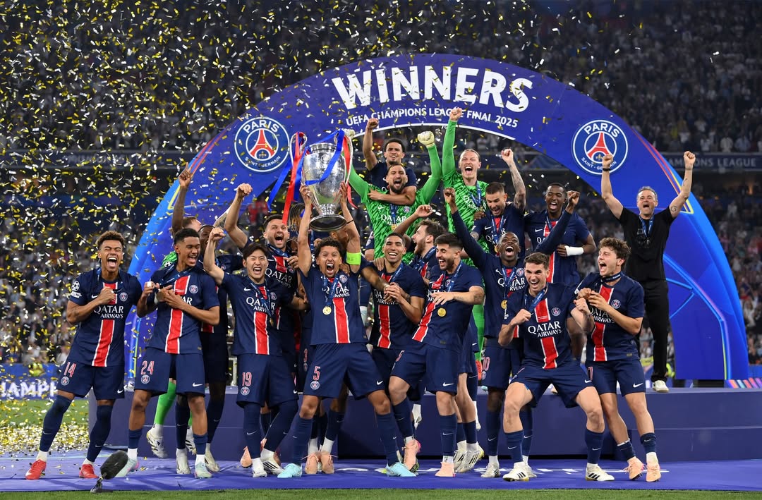 Capitão Marquinhos erguendo o troféu da Champions League, cercado pelo elenco comemorando