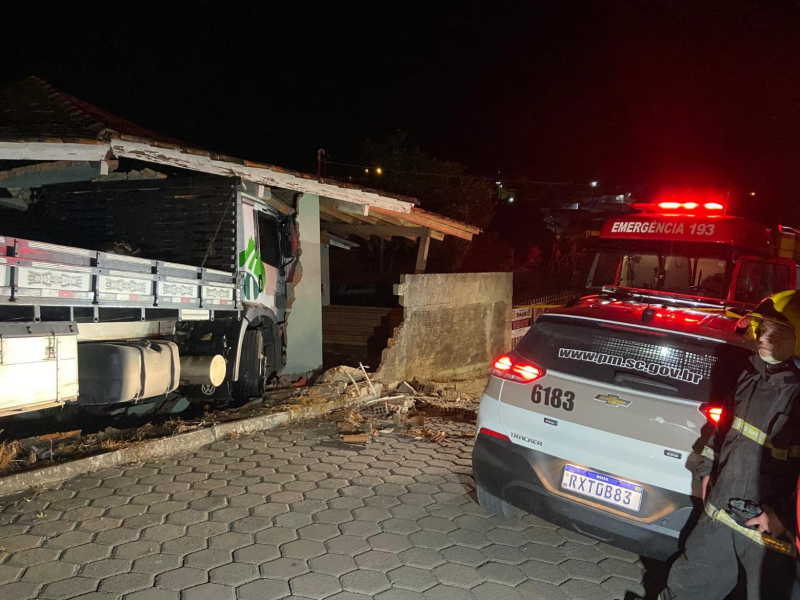 A imagem mostra o caminhão colidido com a casa.