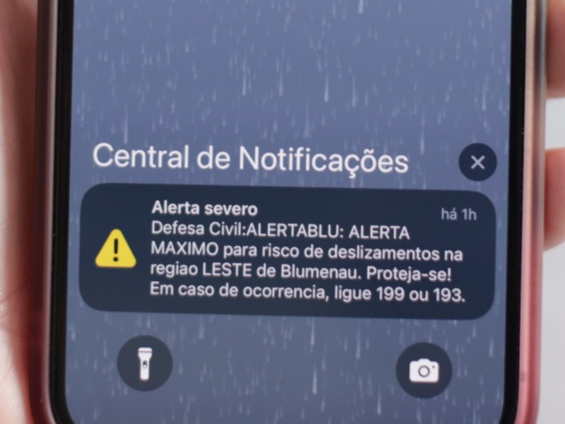 A imagem mostra o alerta da Defesa Civil, dado em Blumenau.