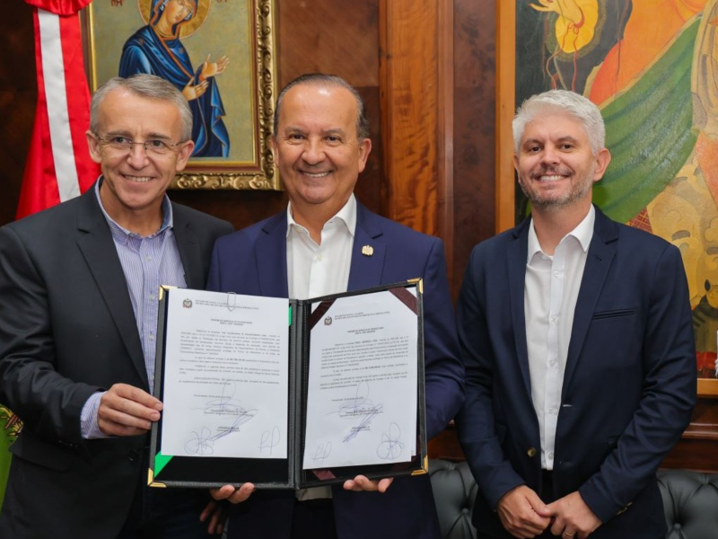 A imagem mostra o governador Jorginho Mello, o secretário de Defesa Civil Mário Hildebrandt e o prefeito de Blumenau Egídio Ferrari, com documento de reforma de diques em Blumenau