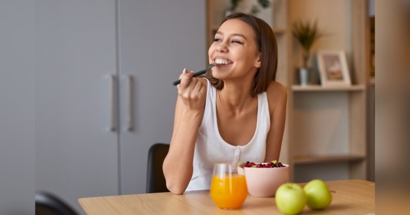 Mulher comendo frutas com suco