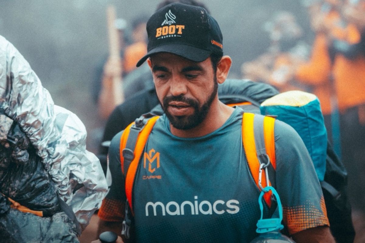 Homem com roupas de acampamento em matéria sobre o dia dos legendários