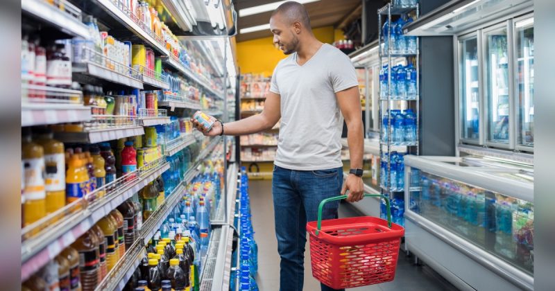 Homem segurando cesta e escolhendo produtos no mercado