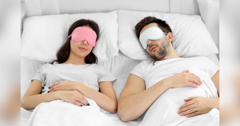 Duas pessoas deitadas em cama com vendas nos olhos 