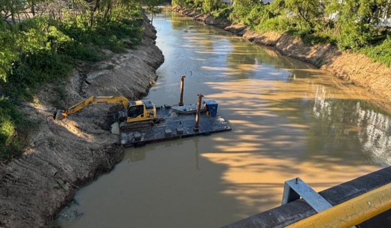 Obras da Defesa Civil em rios, foto mostra rio com máquina dentro