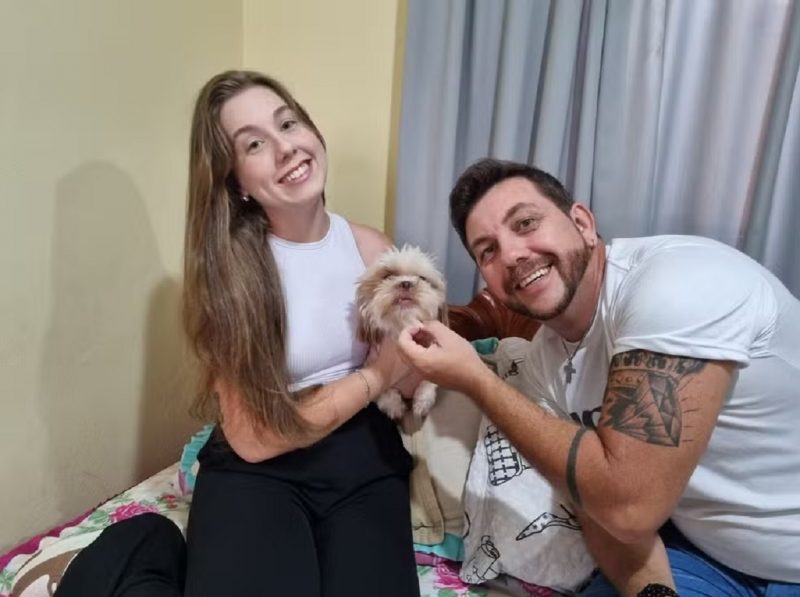 Pai e filha segurando o pet da família 