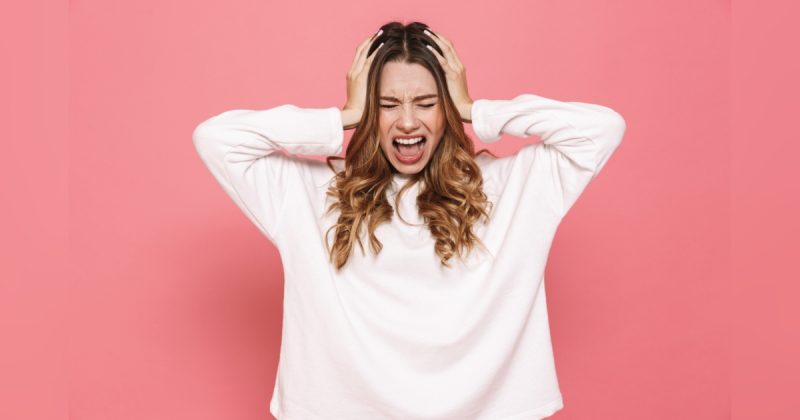 Mulher estressada com mãos na cabeça e gritando