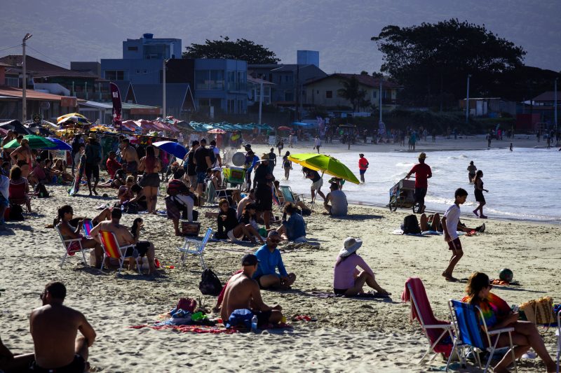 Praia da Barra da Lagoa, em Florianópolis, lotada em dia ensolarado