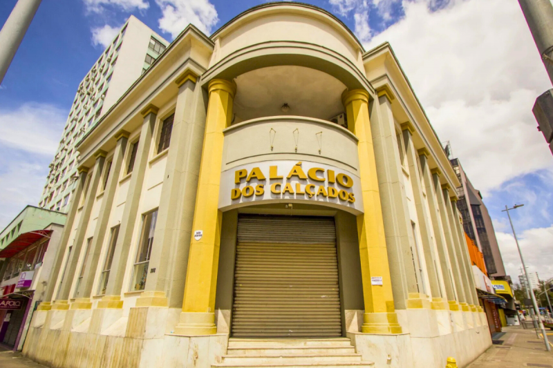 Casarão de dois andares e de esquina na esquina da Rua do Príncipe com a Rua 9 de Março, em Joinville. A fachada do prédio na porta de entrada é arredondada e conta com várias colunas. 