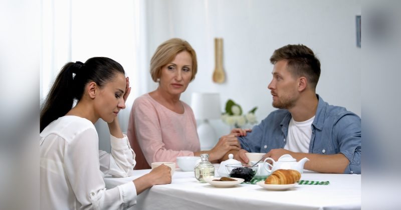 Mulher com rosto esnobe enquanto tem pessoas sentadas na mesa