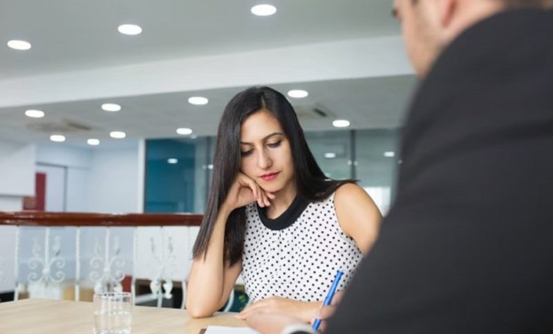 na foto aparece uma mulher que costuma tocar o rosto durante entrevista de emprego