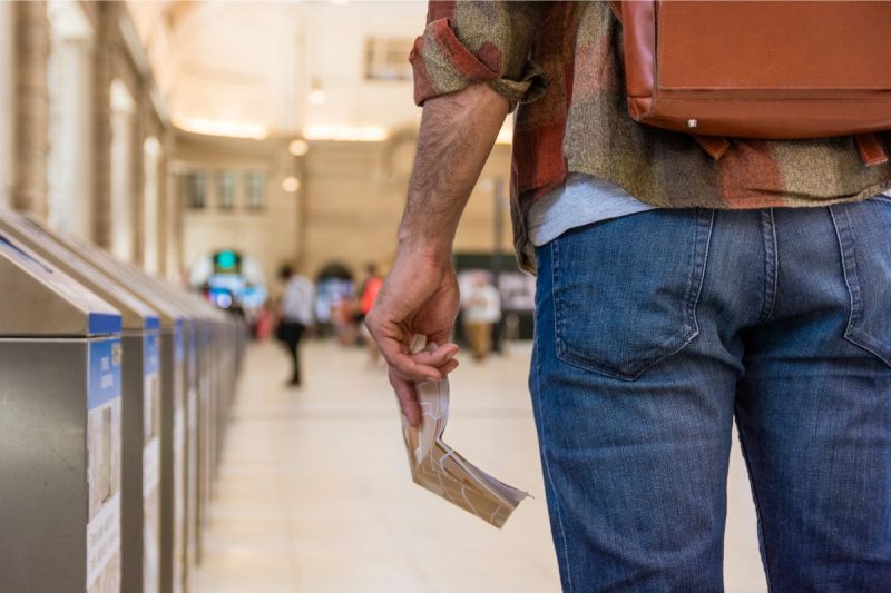 Homem com passagem na mão esperando algo