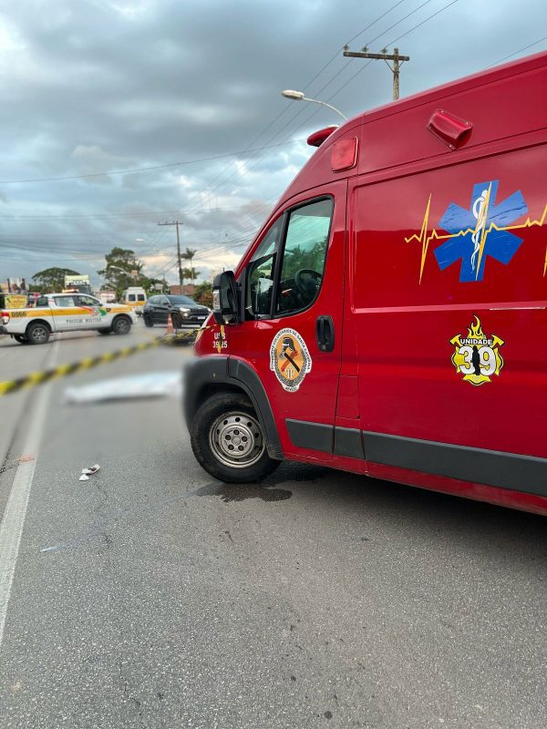 Corpo de motociclista que morreu atropelado por ônibus sobre a via 