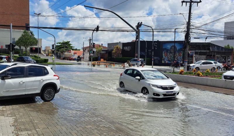 Adutora rompe e deixa nove bairros sem água em Florianópolis. Na imagem, carros circulam na rua alagada.