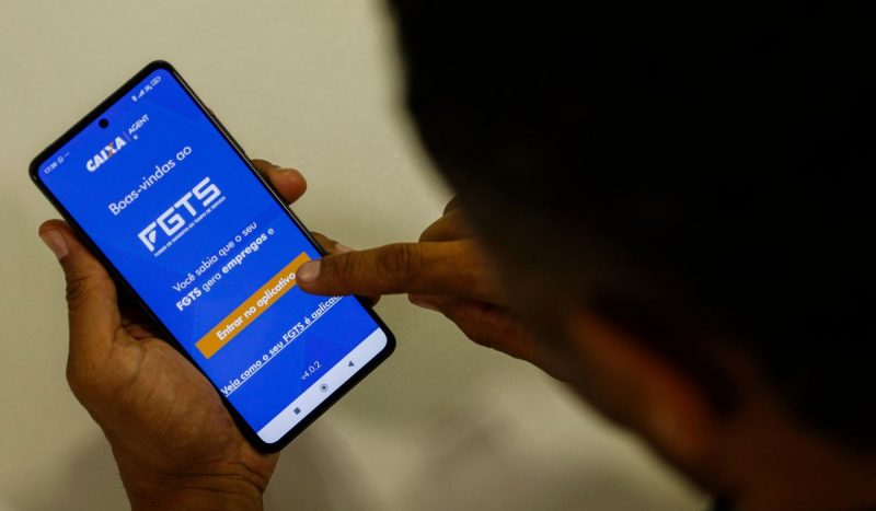 Celular com aplicativo do FGTS aberto em referência ao saque para trabalhadores