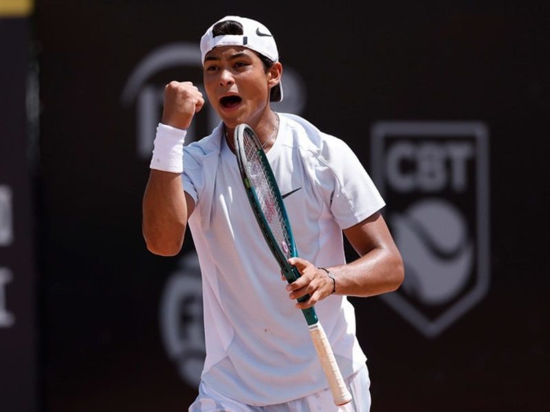 Atleta brasileiro Luis Guto Miguel celebrando ponto em torneio mundial de tênis juvenil