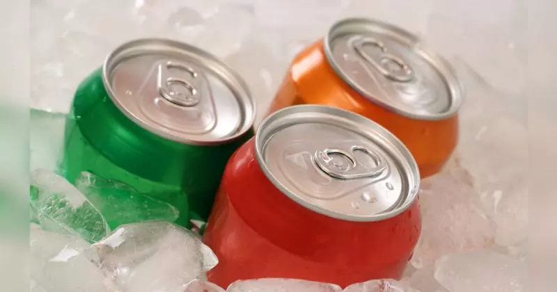 Refrigerantes com latas verde, vermelho e laranja em gelo